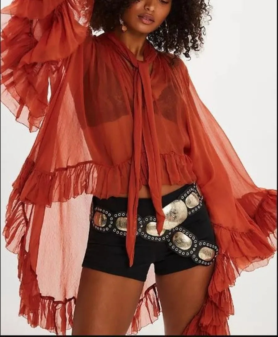 Blusa semitransparente tipo capa con lazo de BB Bellezachic, con detalles elegantes y diseño delicado en tela ligera.